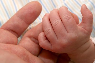 baby hand holding an adult's finger