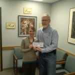 Knight of Columbus, Michael Wolter, presents funds to Refugee Resettlement Director, Kristina Hammell